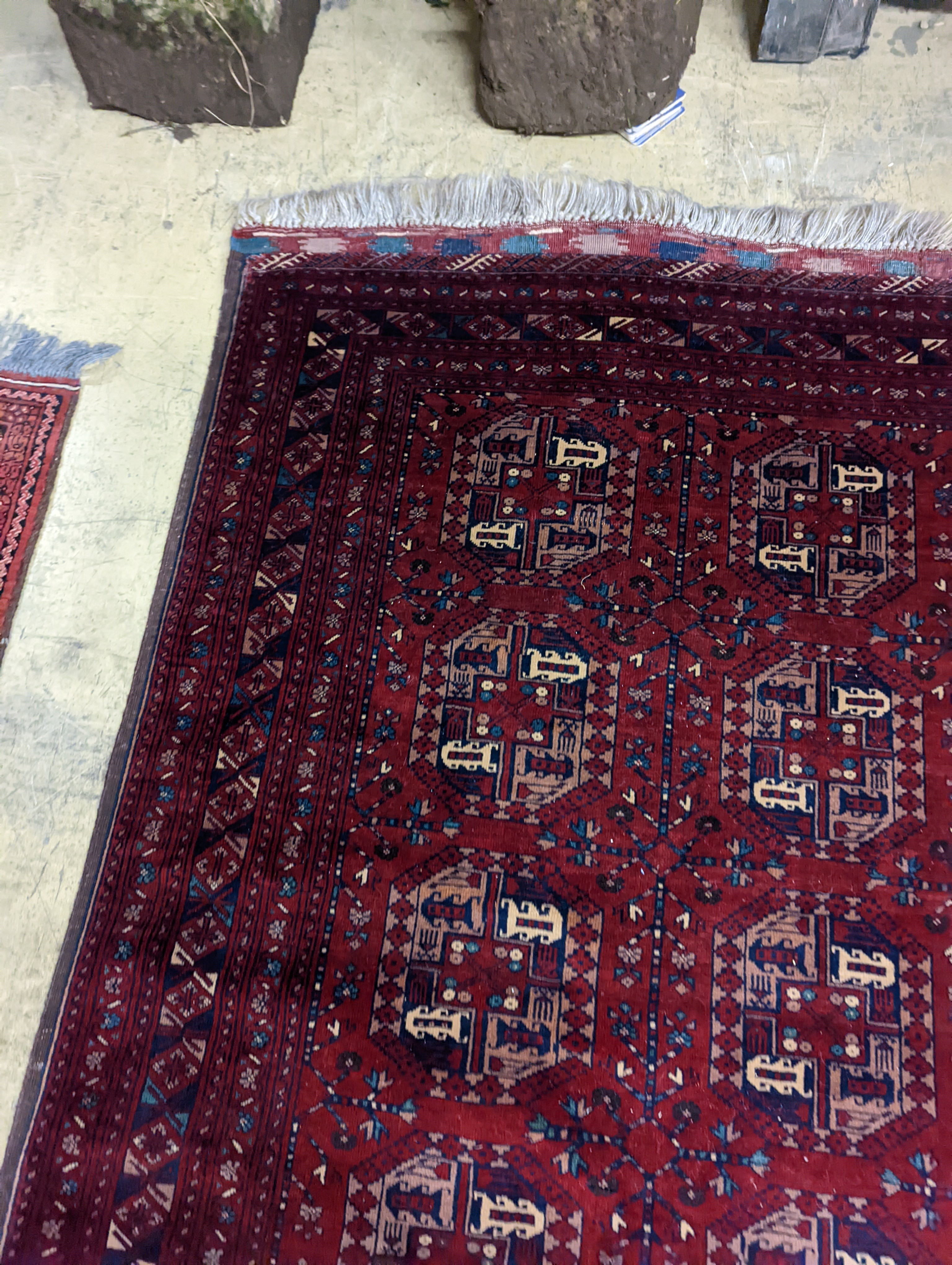 A Belouch red ground rug woven with octagonal motifs, 190 x 124 cms.
